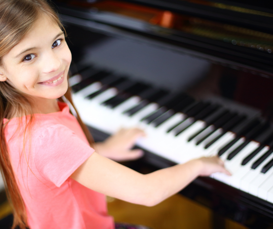 Young student smiling at the piano during a group class