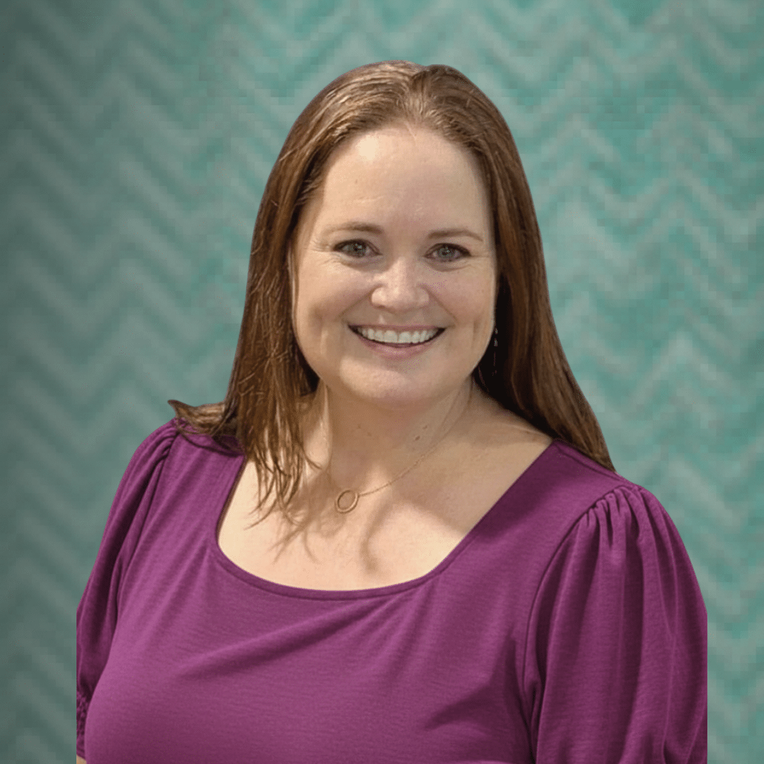 Ms. Katherine, Founder and Owner, smiling in a magenta top against a teal chevron backdrop